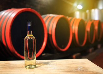 Wine barrels in wine-vaults in order with glass of wine