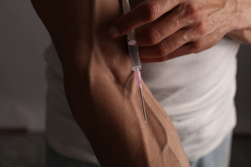 Sport man injecting himself with steroids, closeup