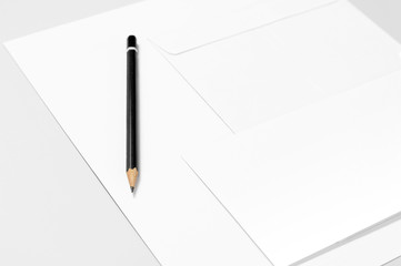 Blank stationery: sheets of paper and pencil over gray background