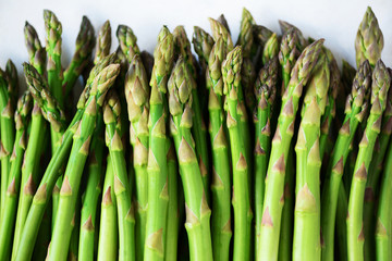 Green fresh asparagus on gray background. Top view. Raw, vegan, vegetarian and clean eating concept.