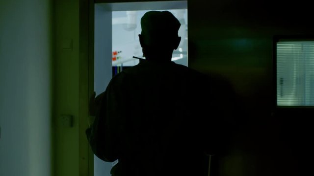 Senior Surgeon Enters Operating Room Where His Assistants and Patient Wait, He Puts on a Mask and Starts Surgery. Shot on RED EPIC-W 8K Helium Cinema Camera.