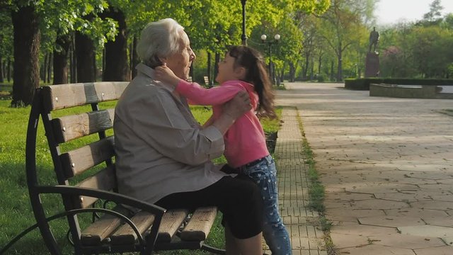 The child plays with the grandmother. Granddaughter with grandmother in the park.