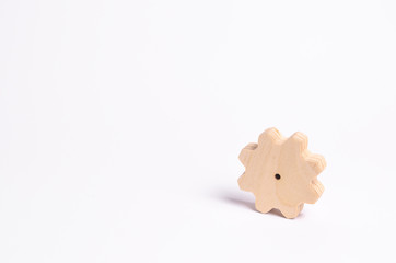 Wooden gear on a white background. Abstract background for presentations and banners. The concept of technology and industry, the think process. Part of a large complex mechanism.
