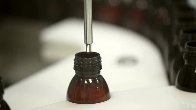 One of the steps. Closeup shot of a production machine filling bottles with liquid pharmaceuticals on the conveyor