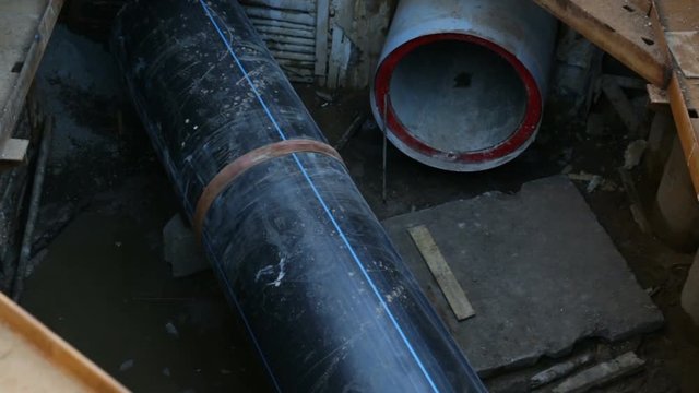 Top view of large plastic PEX pipes on the construction site, in a specially designed pit. Outdoor, construction site, dry season, summer, signal in