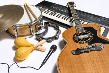 a group of musical instruments including a guitar, drum, keyboard, tambourine.