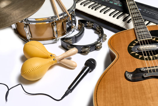 a group of musical instruments including a guitar, drum, keyboard, tambourine.