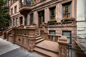 A brownstone building with colorful flowers in a neighborhood of Manhattan, New York City