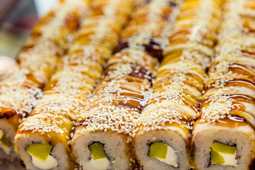 Rolls in the window in the sushi bar. Traditional Japanese food to takeaway. Organic natural products. Seafood. Serving delicacies