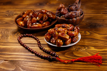 Dates fruit and rosary on wooden table