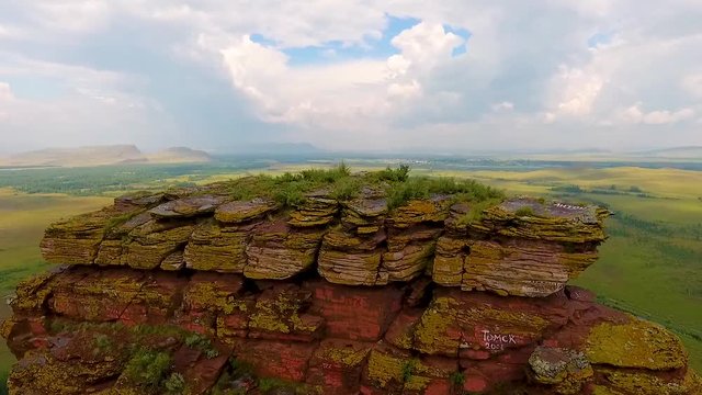 Aerial view of the mountain range Sunduki, green fields sky before the storm in the Republic of Khakassia. Russia