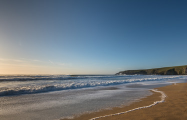 Fototapeta na wymiar Foamy Waves at a sandy beach