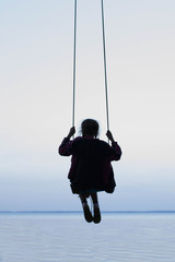 girl on a swing against the sea