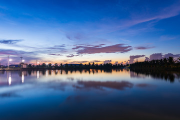 A time traveler at sunrise with a reflection in the lake.