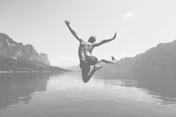 Man jumping with joy by a lake