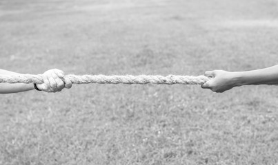 Closeup of hand pulling the rope in tug of war game