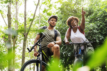 Cyclist couple in the forest - obrazy, fototapety, plakaty