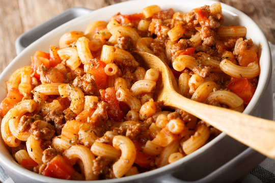Italian American goulash with pasta, beef and tomatoes close-up in a saucepan. horizontal