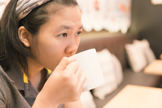 Young woman drink coffee in cafe with vintage tone.