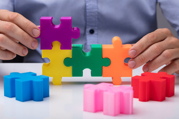 Person Connecting Multicolored Jigsaw Puzzle