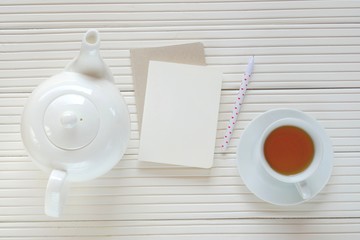 Morning tea flat lay.tea with blank notebook on a light wooden  background.  top view, copy space