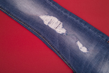 Ripped jeans light blue on a red background