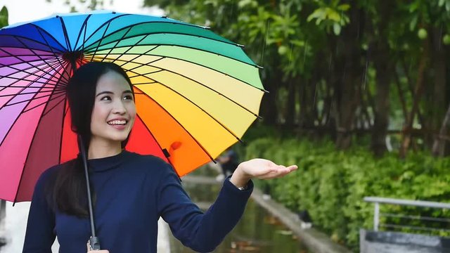 Young beautiful happy woman under rainbow umbrella 