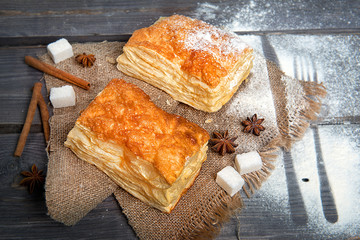 Sweet puffs with sugar on a wooden table. Advertising still life from baking.