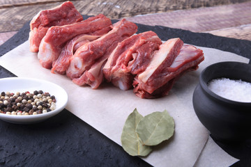 Raw fresh meat, uncooked lamb or beef ribs with pepper, garlic, salt and spices on dark stone background, Ready for cooking. copy space.