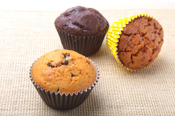 Assorted with Delicious homemade cupcakes with raisins and chocolate isolated on textile background. Muffins. Top view.