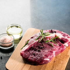 Fresh raw Prime Black Angus beef steaks on wooden board: