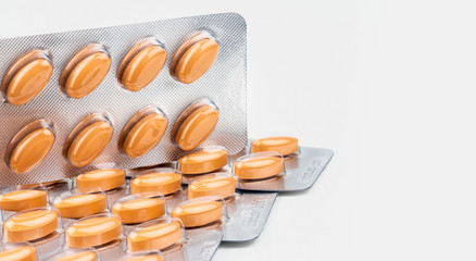 Orange oval tablet pills isolated on white background. Medicine for treating venous circulation...