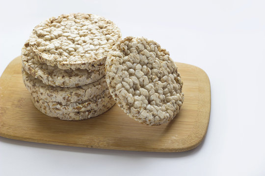 Stack of round rice crispbreads on wooden board. Concept of healthy diet with copy space.