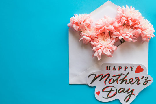 Pink flowers and greeting card on blue background. Happy Mother's Day.floral greeting card concept, flat lay. mothers day. tender spring image