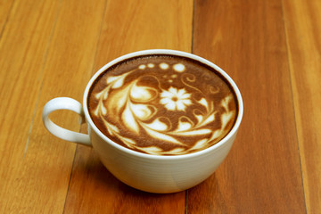 Hot coffee mocha decorated on wooden background, latte art.
