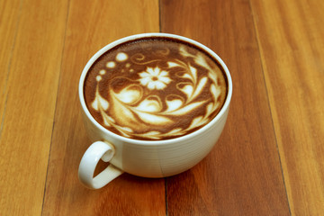 Hot coffee mocha decorated on wooden background, latte art.