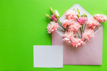Mother's Day concept. Bouquet of pink lisianthus, chrysanthemums with envelope. Blank paper note for copy space.card in mother's day, wedding invitation, anniversary or fill word in special