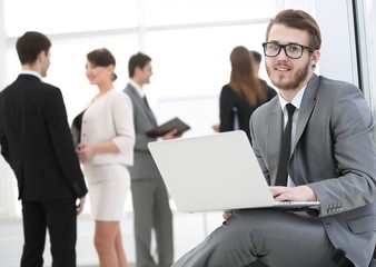 Manager with documents on the background of colleagues