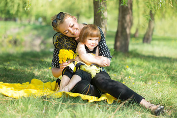 Fototapeta premium happy mother with little daughter dressed in costume bees walking in sunny park on nature in spring