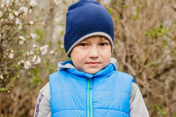 cute little boy in blue cap spring in the garden