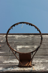 Broken basketball hoop without net and a scratched backboard.