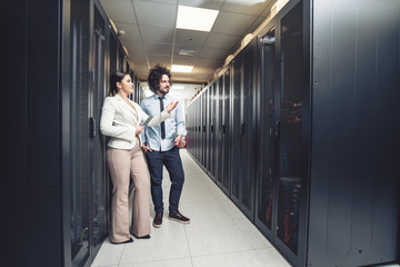 Fototapeta premium Man and woman working on servers at data center