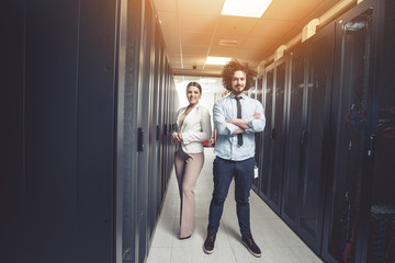 Man and woman working on servers at data center