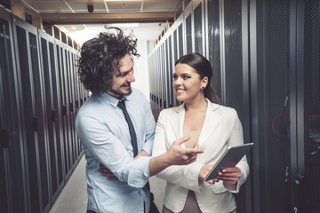 Man and woman working on servers at data center