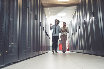 Man and woman working on servers at data center