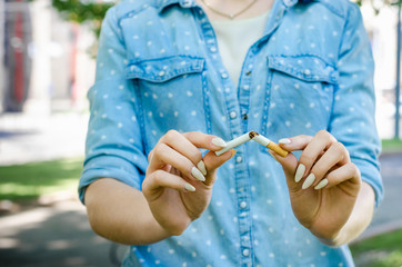 Close Up Of Stylish Smiling Woman Smoking Cigarette Outdoor Denim Shirt in park on Nature...