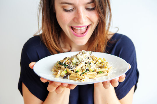 Young Woman Holding A White Plate With Pasta And Cheese