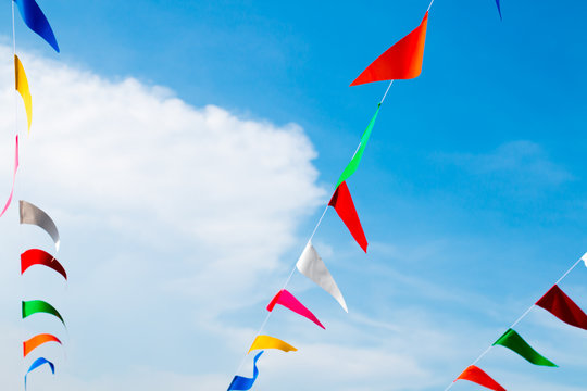 Multi color triangular flags with clear blue sky and cloud, outdoor celebration party