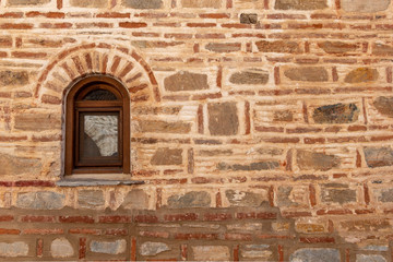 Fototapeta premium Window on the façade of stone wall