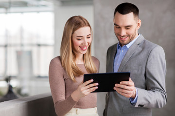 business people, technology and corporate concept - happy smiling businesswoman and businessman with tablet pc computer at office